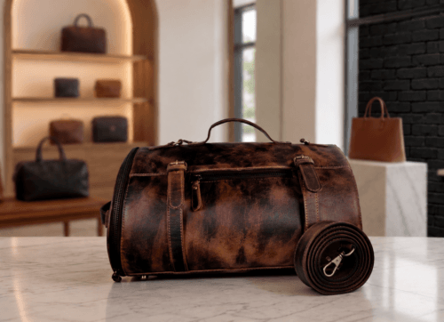 DayLife Leather handcrafted distressed brown leather duffle bag with a matching shoulder strap on a marble surface, available at daylifeleather.com.