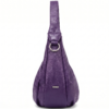 Side profile of Daylife Leather vibrant purple ruched slouchy hobo bag standing on a rustic wooden table.