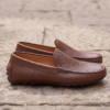 Close-up shot of a man wearing premium brown textured leather loafers, comfortable slip-on leather shoes for men.