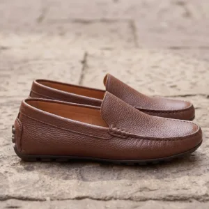 Close-up shot of a man wearing premium brown textured leather loafers, comfortable slip-on leather shoes for men.
