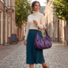 Side profile of Daylife Leather vibrant purple ruched slouchy hobo bag standing on a rustic wooden table.