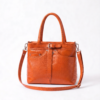 Professional woman wearing a beige blazer styling a DayLife Leather orange croco-textured office bag for women.