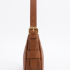 Side profile of DayLife Leather tan brown leather bag highlighting the slim profile, pebbled texture, and strap adjustment buckle.