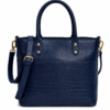 Front view of a dark blue croc-embossed leather tote bag by DayLife Leather, featuring gold hardware, an adjustable strap, and a brown leather logo tag, resting on a wooden table.