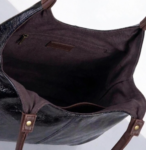 Screenshot 2026-07-26 230625 Daylife Leather dual-tone hobo shoulder bag featuring a glossy black leather body and brown handles against a beige background.
