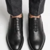 Top-down view of the sleek, closed-lacing design of the black leather Oxford shoes.