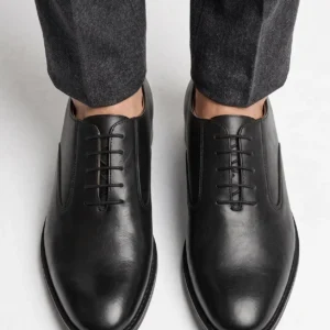 Top-down view of the sleek, closed-lacing design of the black leather Oxford shoes.