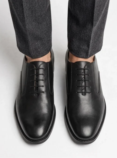 Top-down view of the sleek, closed-lacing design of the black leather Oxford shoes.