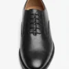 Three-quarter front angle view of a pair of polished black leather Oxford shoes isolated on a white background.