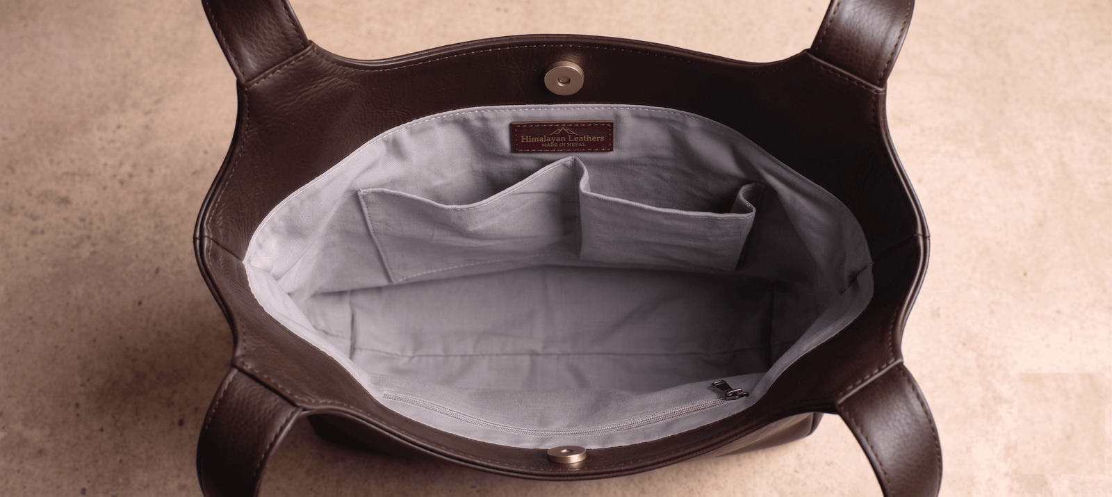 Brown leather hobo bag styled with perfume and mirror on vanity