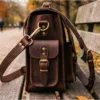 DayLife Leather vintage brown full-grain leather messenger bag resting on a wooden bench in a park.