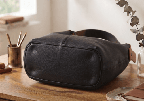 Black leather hobo shoulder bag with brown adjustable strap