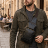 Handcrafted black textured leather sling bag with antique brass zippers and adjustable crossbody strap