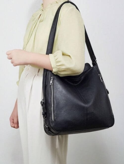 Handcrafted black leather convertible shoulder bag and backpack with multi-pocket design