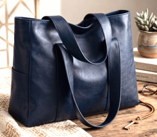 blue_hobo5 Navy blue handcrafted leather tote bag with sturdy shoulder straps and side pockets on a display stand.