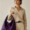 Deep purple genuine leather hobo bag with gold buckle strap on wooden surface