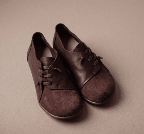 Dark brown leather and suede lace-up shoes for women, close-up texture view