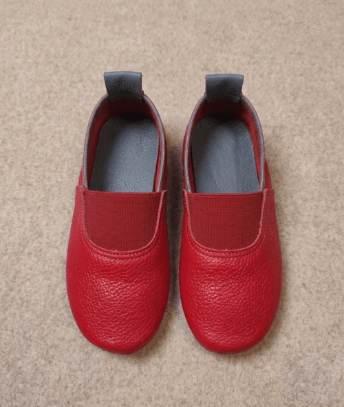 Maroon Genuine Leather Slip-On Loafers for Women Woman wearing maroon genuine leather slip-on loafers with cream trousers