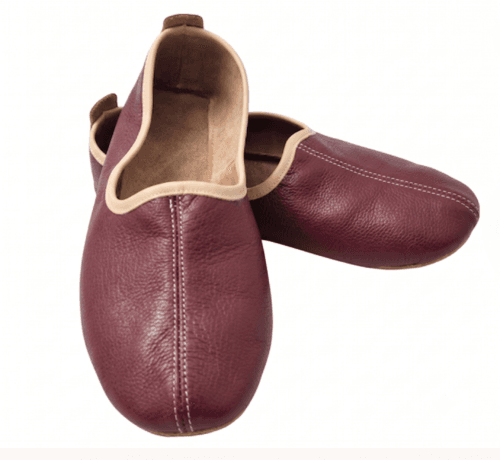 Men's maroon leather juti slip-on shoes with beige piping and suede-lined interior, side view