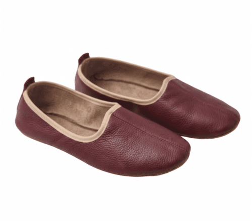 Men's maroon leather juti slip-on shoes with beige piping and suede-lined interior, side view