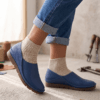 Men's navy blue pebbled leather slip-on shoes with beige ribbed sock-style collar and brown rubber sole