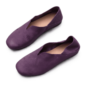 Handcrafted Deep Purple V-Cut Pebbled Leather Flat Shoes - Three-View Display A product photography composite image showing a pair of handcrafted deep purple, pebbled leather flat shoes arranged in three views on a light gray background. The left panel shows the top-down (upper) view, the center panel shows the side profile, and the right panel shows the rear (back) view.