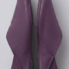 A product photography composite image showing a pair of handcrafted deep purple, pebbled leather flat shoes arranged in three views on a light gray background. The left panel shows the top-down (upper) view, the center panel shows the side profile, and the right panel shows the rear (back) view.