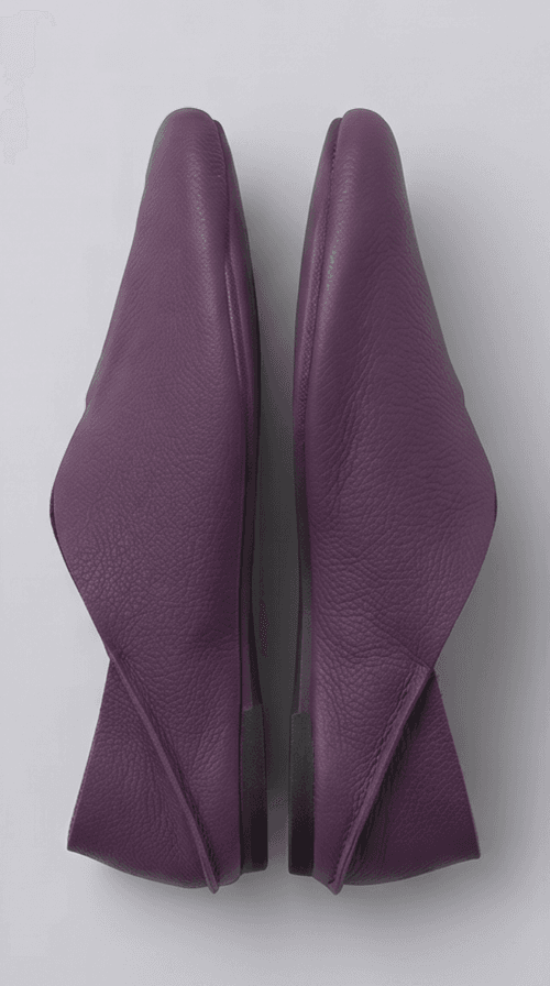 A product photography composite image showing a pair of handcrafted deep purple, pebbled leather flat shoes arranged in three views on a light gray background. The left panel shows the top-down (upper) view, the center panel shows the side profile, and the right panel shows the rear (back) view.