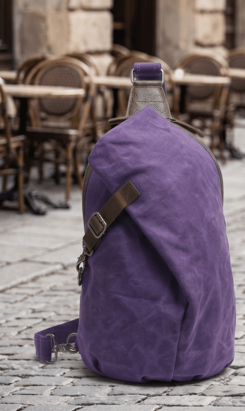 Male model wearing a vintage purple waxed canvas crossbody sling backpack by Daylife Leather on an urban cobblestone street, featuring product close-up and open interior view.