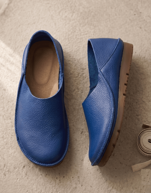 Men's navy blue pebbled leather slip-on shoes with beige ribbed sock-style collar and brown rubber sole